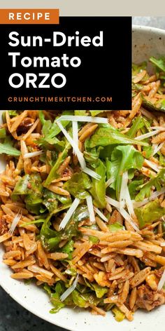 sun dried tomato orzo with shredded cheese and lettuce in a white bowl