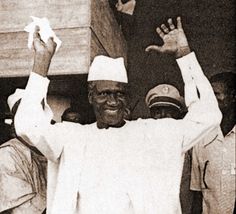 a black and white photo of a man holding his hands up in the air with two other men standing behind him