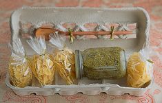 four pasta shells in an egg carton with spices and seasoning on the side