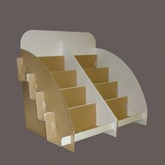 an open cardboard box with stairs on the bottom and sides in white, against a gray background