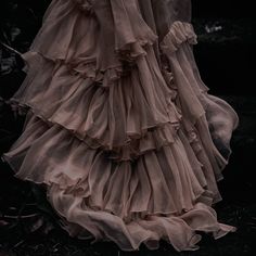 a woman in a long dress with ruffles on it