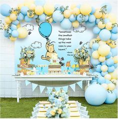 a winnie the pooh birthday party with balloons and dessert table set up on grass