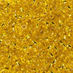 many yellow beads are scattered together on the surface in this close up photo, as if they were made out of glass or plastic