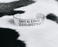 a silver bracelet that says, don't go kissin cowboys on the side