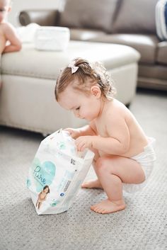 a baby playing with a diaper on the floor