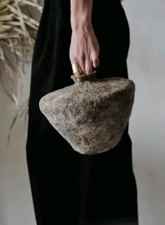 a woman is holding a rock in her hand