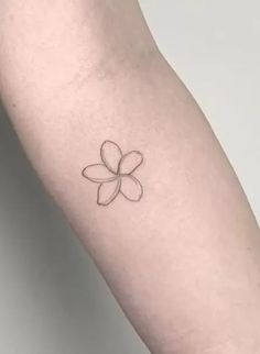 a small flower tattoo on the left forearm and arm, with an outline in the middle