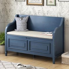 a blue bench with two drawers and a pillow on it in front of a wall