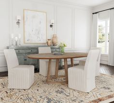 a dining room table with four chairs and a rug on the floor in front of it