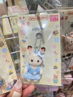 the keychain is shaped like a mouse in a blue dress with a bow on it's head