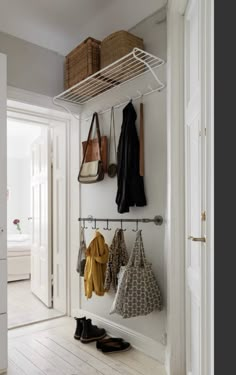 an entryway with coat racks, shoes and purses