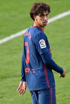 a young man standing on top of a soccer field