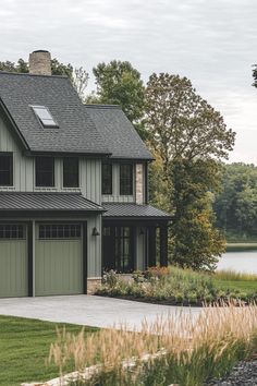 a large house with two garages next to a lake