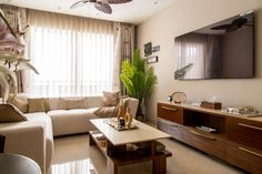 a living room filled with furniture and a flat screen tv mounted to the side of a wall