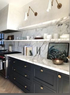 a kitchen with marble counter tops and black cabinets