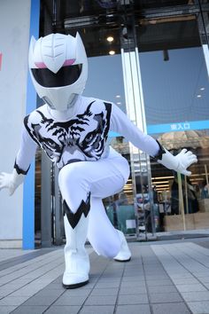 an inflatable man dressed as a white cat stands on one leg and holds his hands out to the side