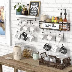 coffee mugs are hanging on the wall above a table