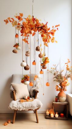 a living room filled with furniture and lots of fall leaves hanging from the ceiling next to a window