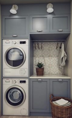 a washer and dryer in a small laundry room with cabinets on the wall