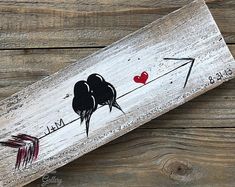 an arrow and heart painted on a wood plank