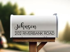 a white mailbox sitting on top of a wooden post