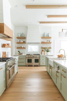 a kitchen with green cabinets and white walls, wood flooring and open shelving