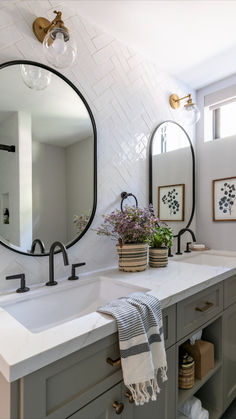 a bathroom with two sinks and mirrors on the wall