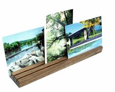 three pictures are placed on a wooden stand