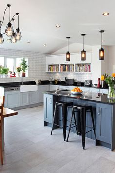 a large kitchen with an island and bar stools