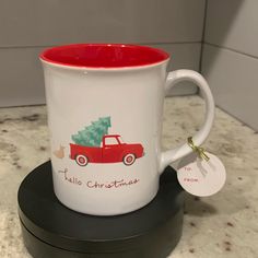 a red and white coffee mug with a christmas tree on it