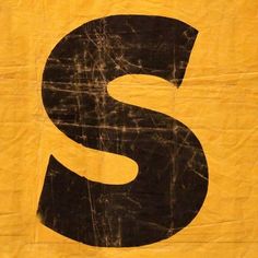 a black and yellow sign with the letter s painted on it's back side