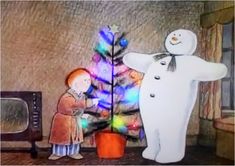 two children are standing in front of a christmas tree with a snowman on it