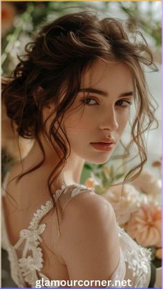 a woman with long hair wearing a white dress and flowers in her hair is looking at the camera