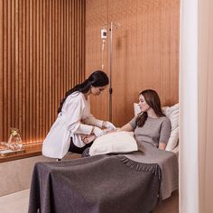 two women in a room getting ready to get their temperature taken