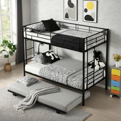 a black metal bunk bed sitting on top of a wooden floor next to a window