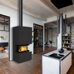 a modern fireplace in the middle of a room with wood flooring and exposed ceilings