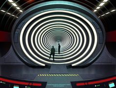 a man standing in the middle of a tunnel with lights coming from it and his shadow on the floor