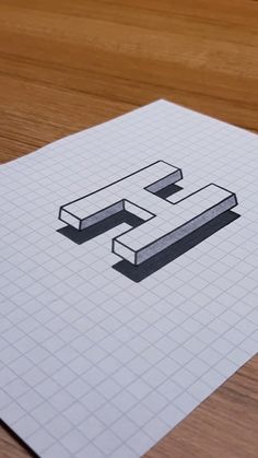 a piece of paper with the letter e on it sitting on top of a wooden table