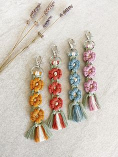 four tasselled key chains with flowers on them