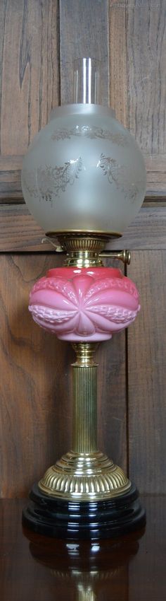 a pink and white lamp sitting on top of a wooden table