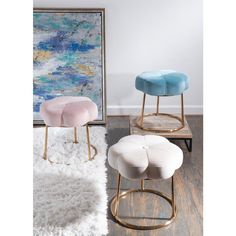 two small stools sitting next to each other on top of a white rug in front of a painting