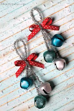 christmas bells are hanging on a chain with red bows and polka dot ribbon around them