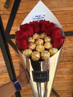 a bouquet of roses and chocolates in a silver vase with a note on it