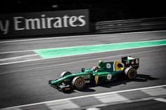 a man driving a green race car on a track