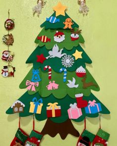 a christmas tree with stockings hanging from it's sides and decorations on the wall