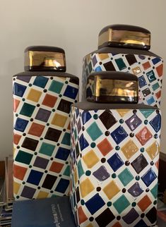 three colorful canisters sitting on top of a table