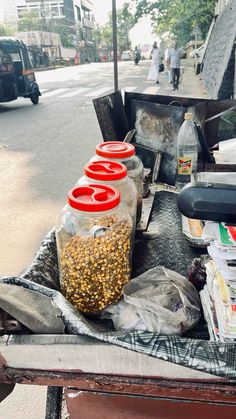 there are three jars on the back of a truck with some food in front of it