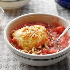 a white bowl filled with food next to bowls of sauce and other items on a table