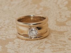 two gold wedding rings with a diamond on top