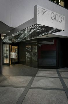 the entrance to an office building with a woman walking in front and another person standing behind it